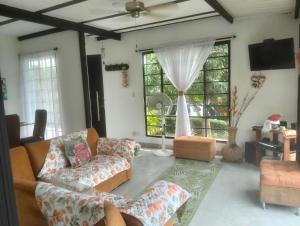 Una sala de estar con sofás y una gran ventana. en Melgar Alojamiento Villa Claudia, en Melgar