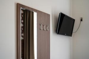 a mirror with two rings on it and a tv at Aadam Wilhelmina Hotel in Amsterdam