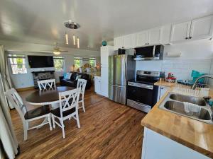 a kitchen and living room with a table and chairs at SeaSide Lake-Front Cottage in Madison +41 photos
