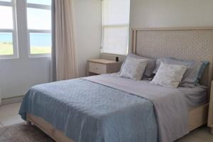 a bedroom with a large bed with a blue blanket at Casa Bellavista - 2BR Beachview Villa by Veritas Pacifica in San Diego