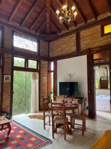 a dining room with a table and chairs and a television at Guest House Tânia Alves in Pratinha