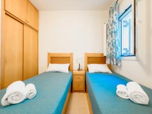two beds in a room with towels on them at Antonio 50 - Blue Glyfada Private Homes in Glyfada