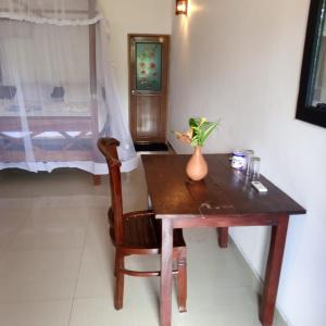 Drewniany stół z wazonem kwiatów na nim w obiekcie Villa Tropi Lanka w mieście Unawatuna