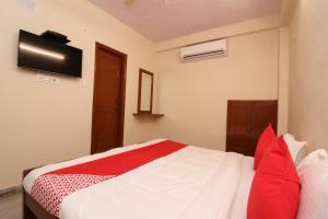 a bedroom with a bed with red pillows at Hotel O Midtown in Bhopal +44 photos