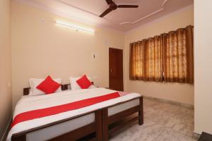 a bedroom with a bed with red pillows at Hotel O Midtown in Bhopal
