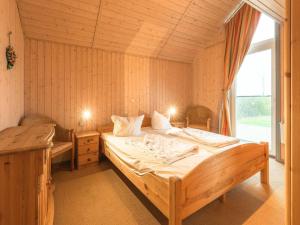 ein Schlafzimmer mit einem großen Bett und einem Fenster in der Unterkunft exklusives skandinavisches Ferienhaus in Rechlin