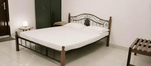 a bed with white sheets and pillows in a bedroom at Bacardi by Stayora in Puducherry