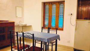 a kitchen with a table and chairs and a refrigerator at Bacardi by Stayora in Puducherry +17 photos