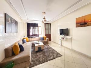 CharfAppartement Plage à vos pieds, gare à 5 min et parking gratuit的客厅里有一张沙发和一台电视