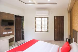 a bedroom with a bed and a sink and a window at Hotel O Eagle Fantasy in Vānivilāsa Puram
