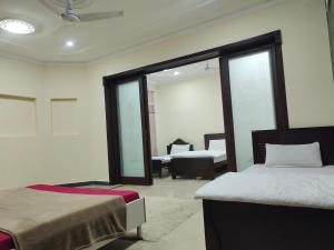 ein Schlafzimmer mit zwei Betten und einem Spiegel in der Unterkunft BnB Islamabad in Rawalpindi