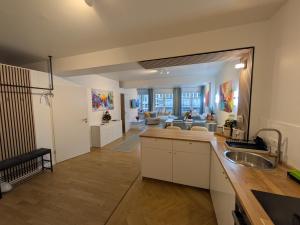 a kitchen with a sink and a living room at Munich Top Place Nähe Marienplatz mit 2 Schlafzimmer 70 qm Apartment Jennifer in Munich