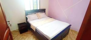 a small bedroom with a bed in a room at Mike's HOUSE in Yaoundé