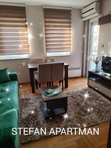 弗尔尼亚奇卡矿泉镇Apartman Stefan Vrnjacka Banja的客厅里有一张绿色的沙发和一张桌子