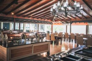 a restaurant with leather chairs and tables and a chandelier at La Regina Lodge in Itatí