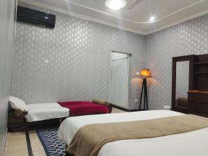 ein Schlafzimmer mit 2 Betten und einer Lampe in der Unterkunft BnB Islamabad in Rawalpindi