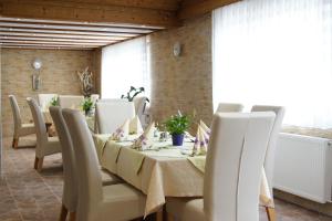 ein Esszimmer mit einem Tisch mit weißen Stühlen und einem Tisch in der Unterkunft Höfener Wirtshaus in Monschau