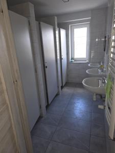 a bathroom with three sinks and a row of toilets at Pyrzowice noclegi AirNest 8 min od Lotniska Katowice Airport 