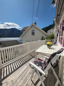 una terraza de madera con una mesa y una silla. en Sjarmerende perle med utsikt mot fjorden, en Sogndal 36 fotos más