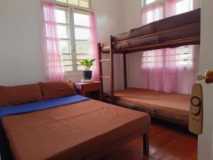 a bedroom with two bunk beds and two windows at A-Seven House Sagada in Sagada