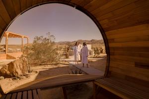 two women standing in an archway looking out at the desert at Quail Wash Retreat - Star Dome I Sauna I Plunge I Spa in Joshua Tree