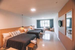 a hotel room with two beds and a couch at La Regina Lodge in Itatí