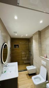 a bathroom with a sink and a toilet and a shower at Gloria New Bazaar Apartment in Tirana