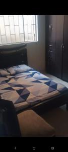 Un dormitorio con una cama con un edredón azul y blanco. en Mónaco 1 piso, en Carmen de Apicalá 4 fotos más