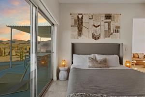 a bedroom with a bed and a balcony at Quail Wash Retreat - Star Dome I Sauna I Plunge I Spa in Joshua Tree +29 photos