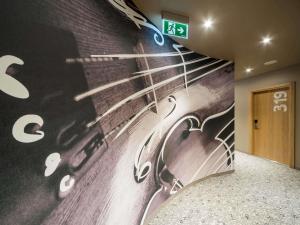 a wall mural in a hallway with a staircase at Ibis Riga Centre in Rīga