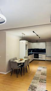 a dining room with a table and chairs and a kitchen at Gloria New Bazaar Apartment in Tirana