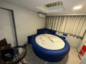 a room with a bed with a blue round bedvisor at Caribe Palace Hotel Samambaia in Brasilia