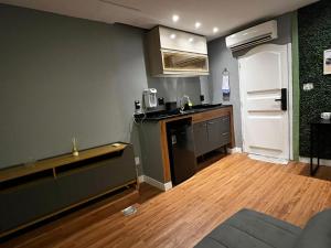 a small kitchen with a counter and a refrigerator at Verdito House in Rio de Janeiro