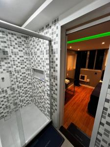 a bathroom with a glass door with a room in it at Verdito House in Rio de Janeiro