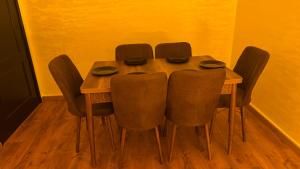 a wooden table with four chairs around it at Suite Bahiya unica in Fez
