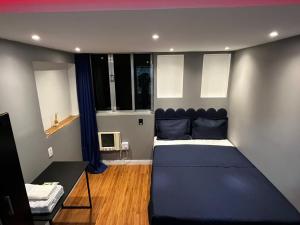 a bedroom with a large blue bed in a room at Verdito House in Rio de Janeiro
