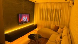 a living room with a couch and a tv on a wall at Suite Bahiya unica in Fez