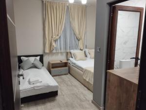 una piccola camera da letto con due letti e una finestra di Странската изба a Kalofer