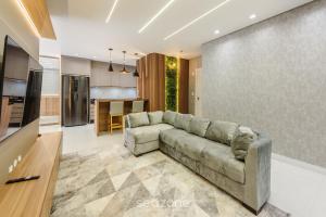 un soggiorno con divano e cucina di Aptos em prédio a 90 m da praia de Perequê - RIHs a Perequê