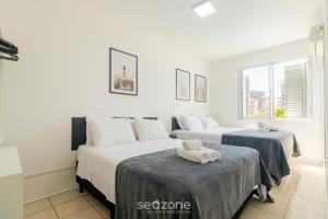 two beds in a room with white walls at Apto a 650 m do MASC em Floripa BAS0401 in Florianópolis