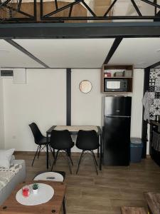 a living room with a table and chairs and a refrigerator at City Loft in Belgrade
