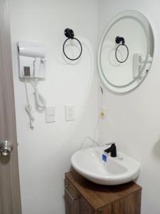 Un baño con un lavabo y un espejo en la pared. en Apartaestudio Armenia quindio, en Armenia 11 fotos más
