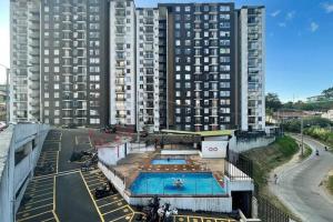 un edificio con una piscina y dos edificios altos en Apartaestudio Armenia quindio, en Armenia