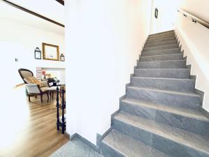 una escalera en una casa con paredes blancas y suelo de madera en ComeCasa Langhe Garden House-Pace e Panorama a Benevello, en Benevello