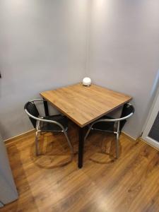 皮拉Apartament Piła Wita的一张木桌,房间内设有两把椅子