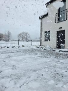a snow covered yard next to a building at Zacisze w Karkonoszach in Karpacz