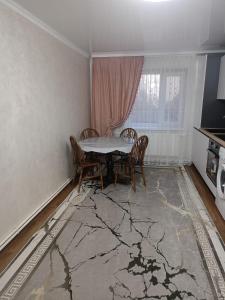 a dining room with a table and chairs and a kitchen at Perla Rosa in Chişinău