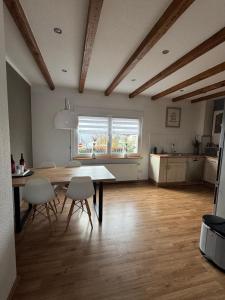 ein Wohnzimmer mit Tisch und Stühlen und eine Küche in der Unterkunft Ferienhaus Auf der Drossel in Gevelsberg