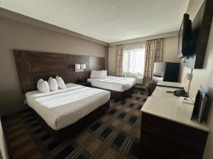 梅迪辛哈特梅迪辛哈特贝蒙特旅馆套房酒店的有两张床和一台电视的酒店房间