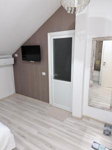a bedroom with a sliding door with a tv on the wall at Taverna to Petrino in Craiova